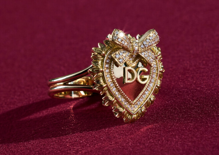 Dolce & Gabbana gold heart ring with a bow and DG lettering on red velvet